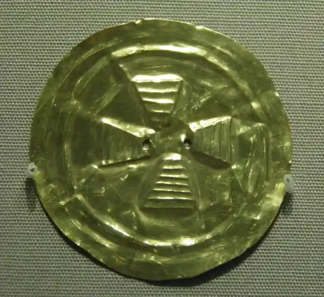 Circular gold disc with a cross in the middle